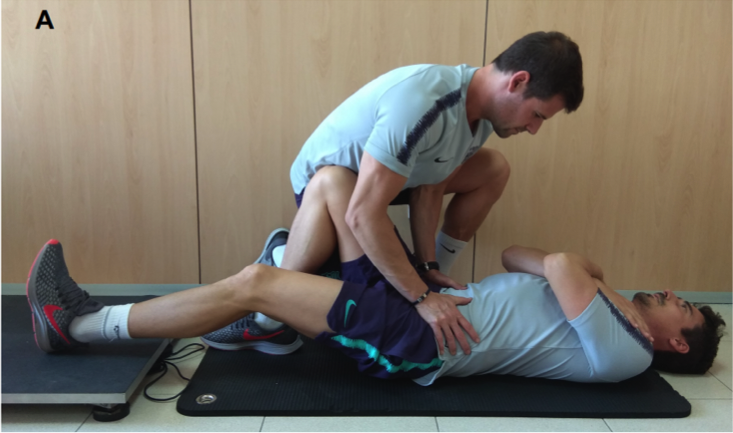 Figura 1. Exemple de realització de la prova isomètrica de la cadena posterior. Font pròpia. NOTA: Tot i que a l’estudi de validació original es col·loca la plataforma de forces en un plint a 30 cm de terra i es mesura l’angle del genoll amb un goniòmetre, al FC Barcelona, per qüestions pràctiques, s’acostuma a posar la plataforma de forces directament a terra.